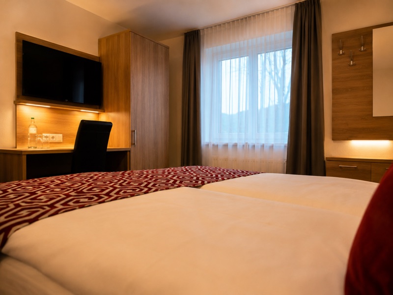 Kompaktes Zimmer mit französischem Doppelbett am Fenster